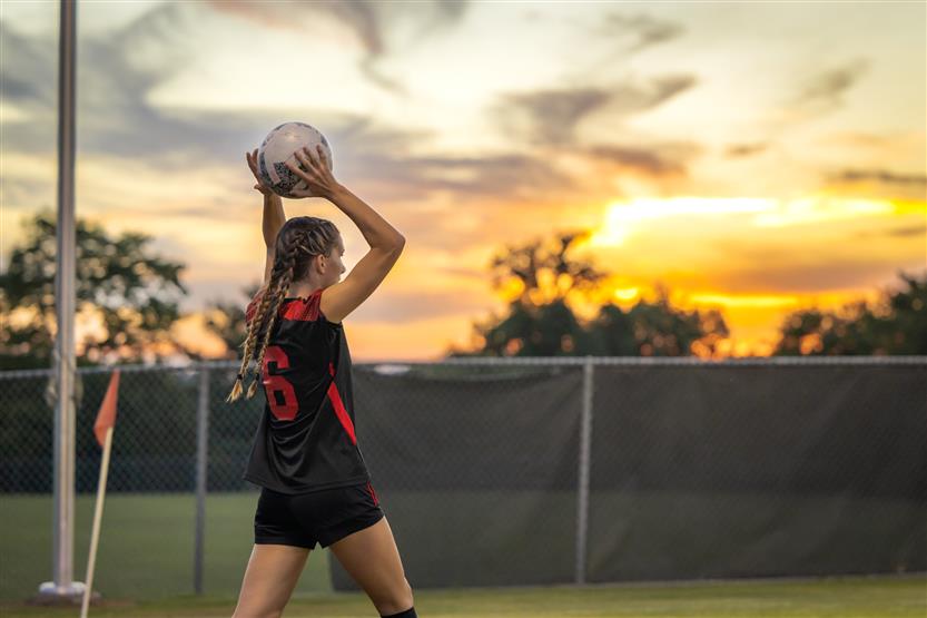 A girl throws in the soccer ball from the sideline